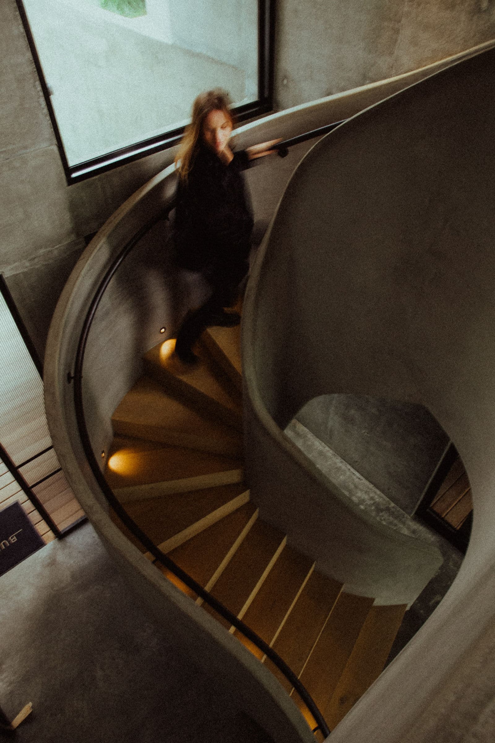 Person walking down a curved indoor staircase